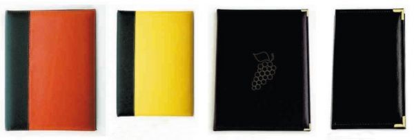 Cuatro cuadernos de diferentes colores están alineados sobre un fondo blanco.