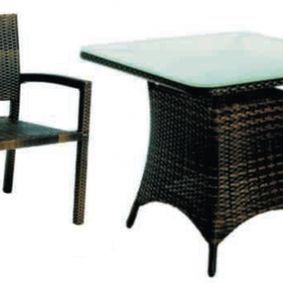 Una mesa y una silla de mimbre sobre un fondo blanco.