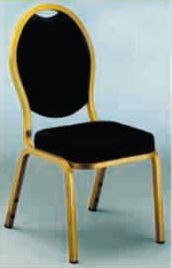 Una silla negra con marco dorado está sobre una mesa.