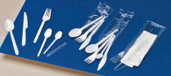 Una fila de utensilios de plástico blanco sobre una superficie azul.