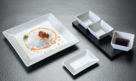 Un plato de comida está sobre una mesa al lado de dos tazones de salsa.