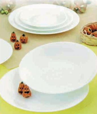 Una mesa cubierta con platos, cuencos y calabazas.