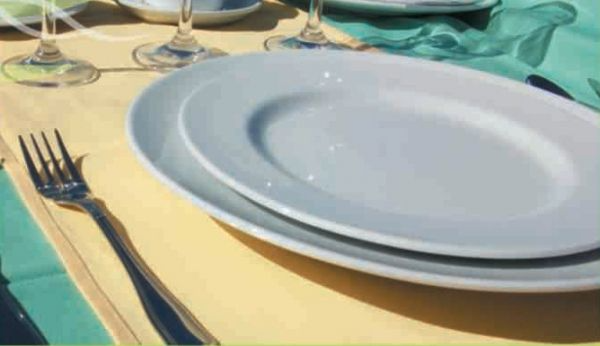 Tres platos blancos están apilados uno encima del otro sobre una mesa.