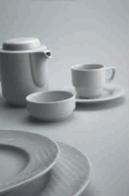 Una mesa cubierta con platos, cuencos, tazas y una tetera.