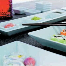 Una mesa cubierta con platos de sushi y palillos.