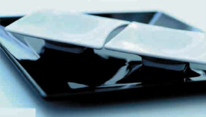 Un plato negro con dos cuadrados blancos encima.