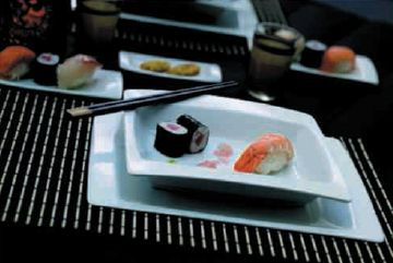 Un plato de sushi con palillos sobre una mesa.