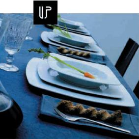 Una fila de platos y vasos sobre una mesa con un logo que dice arriba