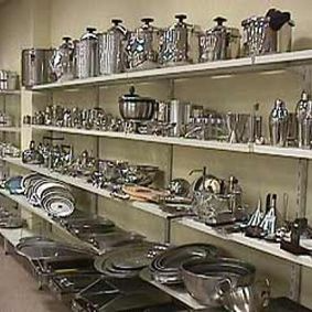 Una tienda llena de ollas y sartenes en los estantes.