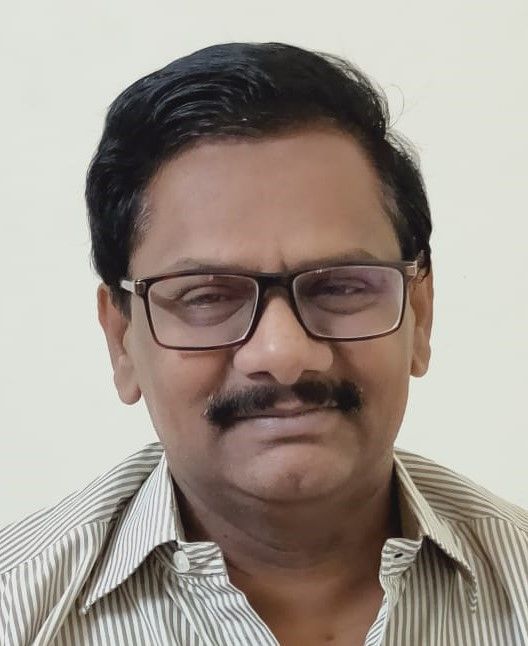 Man with glasses and mustache, in a striped shirt, looking forward.