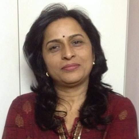 Woman with dark hair, wearing a red patterned shirt, looking at the camera.