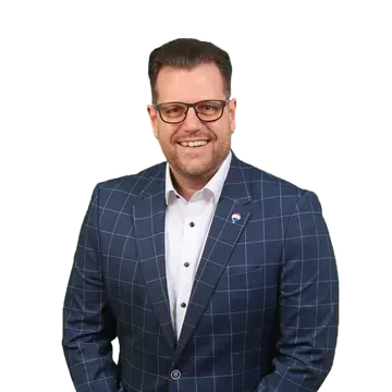 Lächelnder Mann in einem dunkelblauen karierten Anzug und mit Brille vor weißem Hintergrund