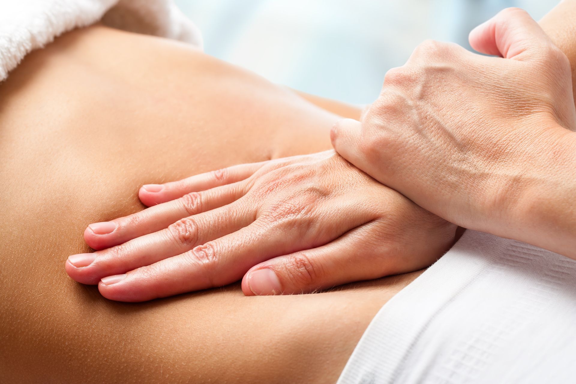 Des mains massent le ventre d'une personne