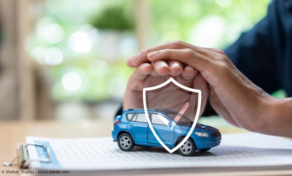 Hände schützen ein blaues Spielzeugauto mit einem Schildsymbol, das den Kfz-Versicherungsschutz symbolisiert.