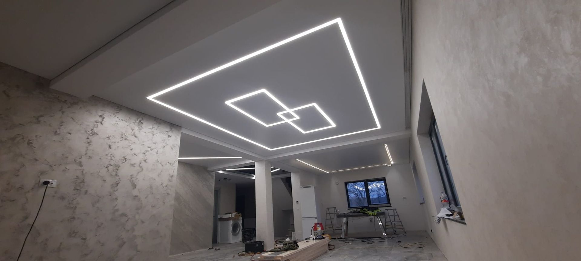 Weisse Decke mit Einbauleuchten und Lüftungsschlitzen. Innenansicht.