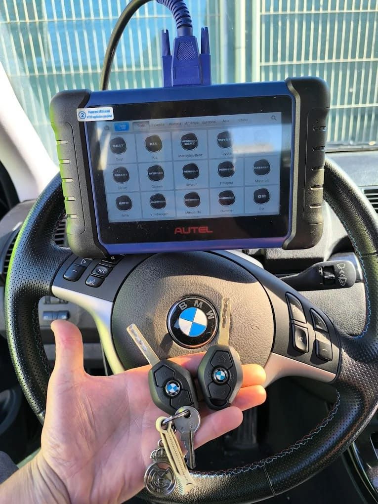 Una persona sostiene un par de llaves delante del volante de un BMW.