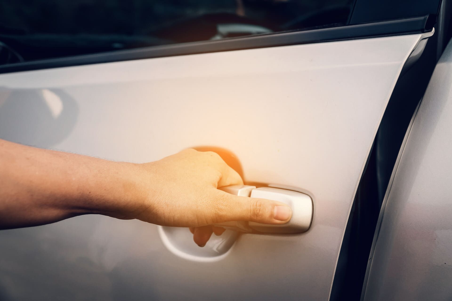 Una persona está abriendo la puerta de un coche.