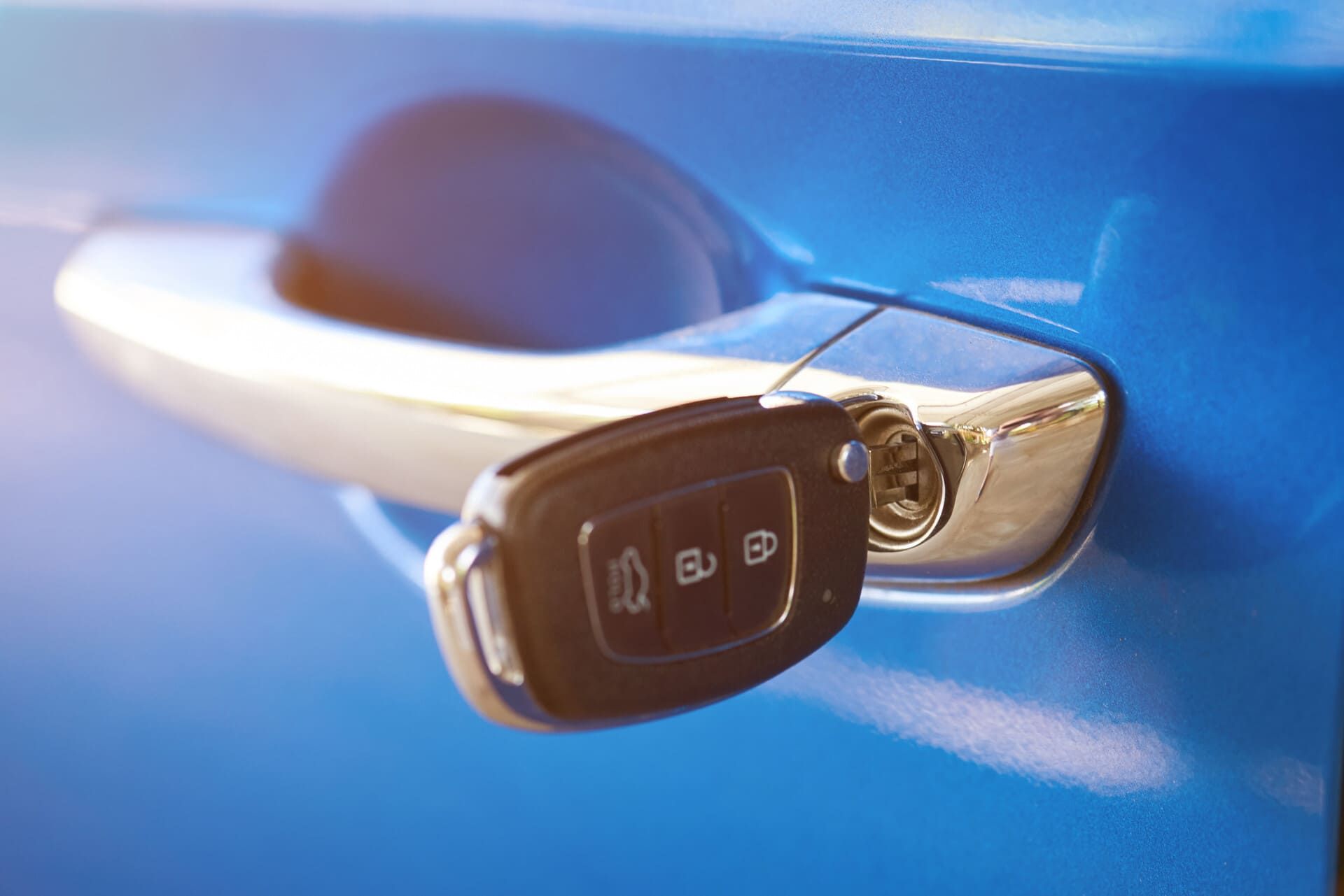 Una llave de coche sobresale de la puerta de un coche azul.