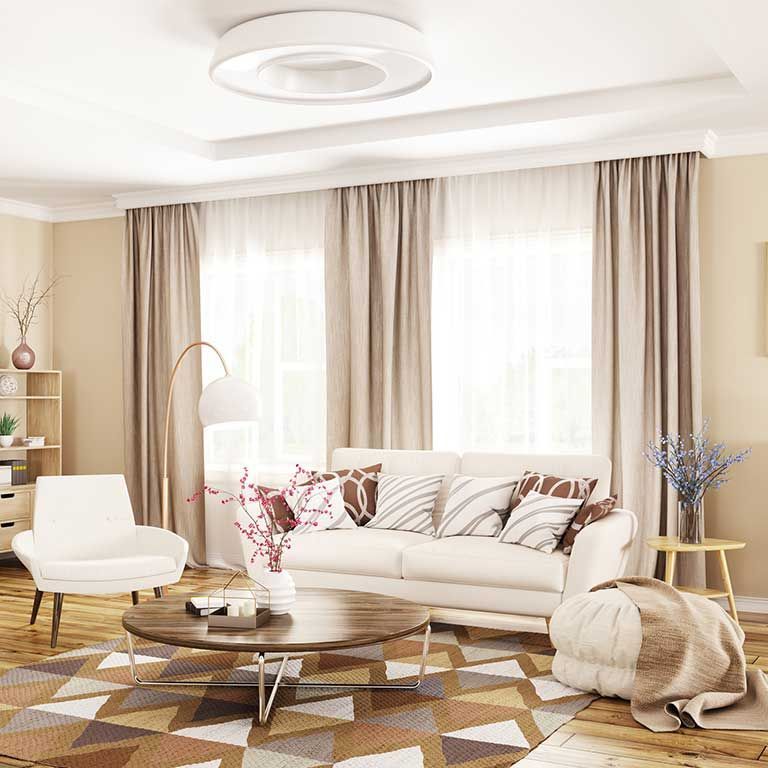 Ein Wohnzimmer mit Couch, Sessel, Couchtisch und Teppich.
