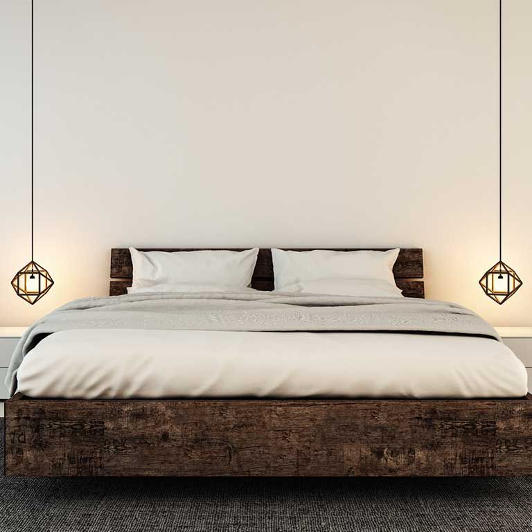 Ein Schlafzimmer mit einem Bett und zwei Lampen, die von der Decke hängen.