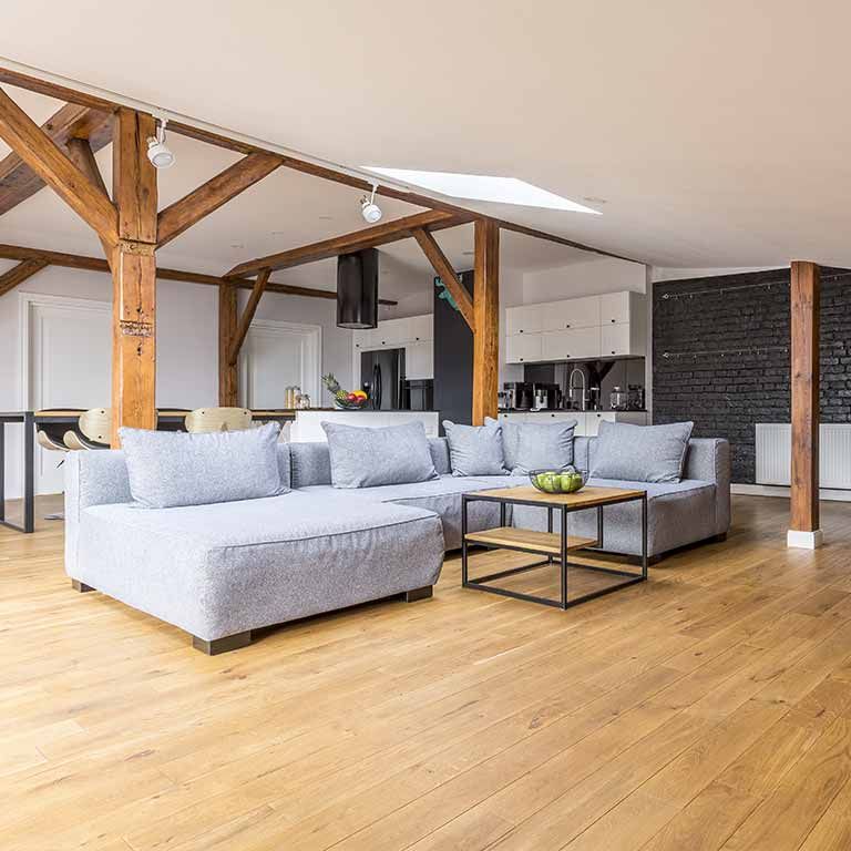 Ein Wohnzimmer mit Couch, Couchtisch und Holzbalken.