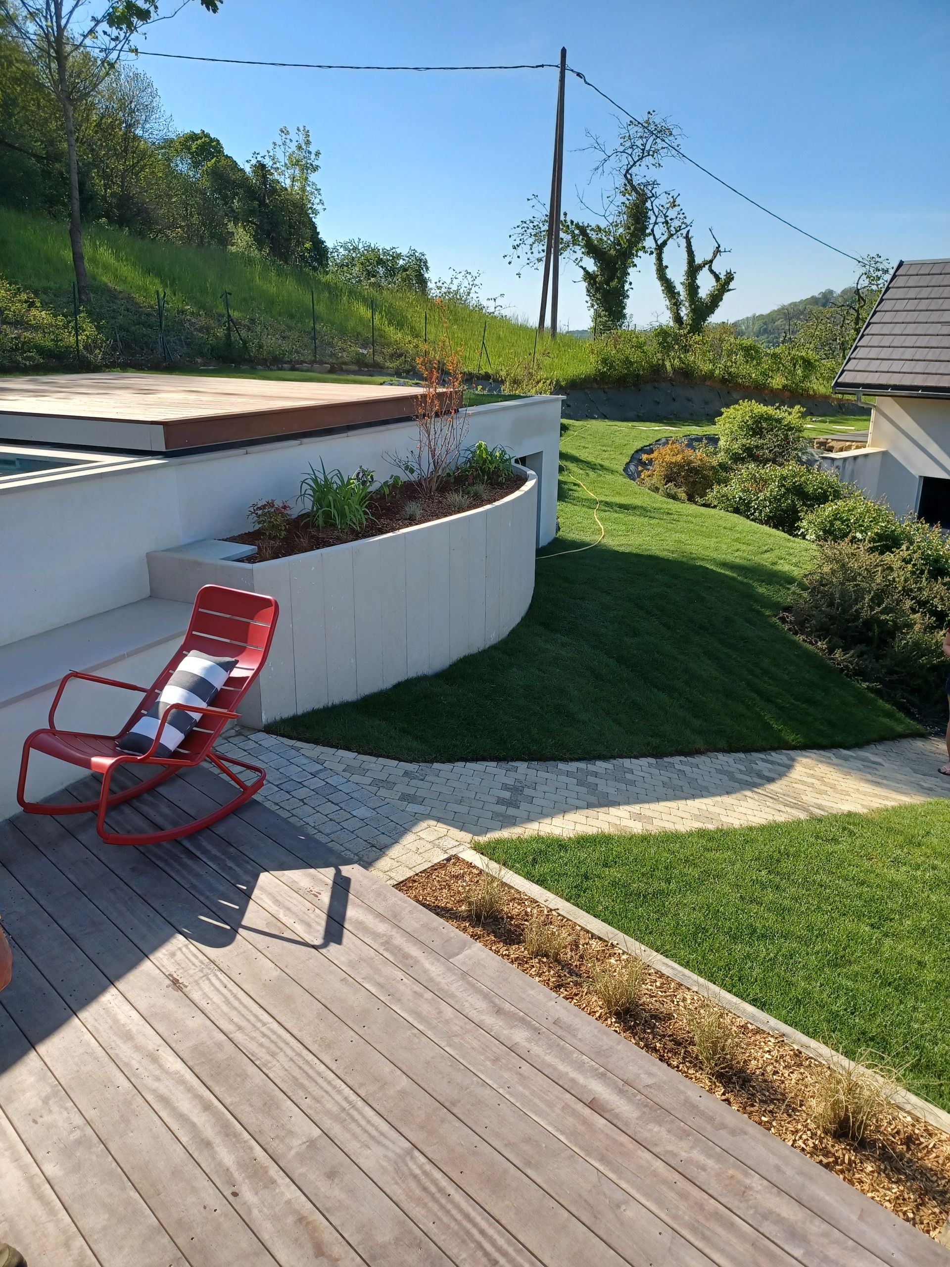Une chaise posée au début d'un chemin en carrelage