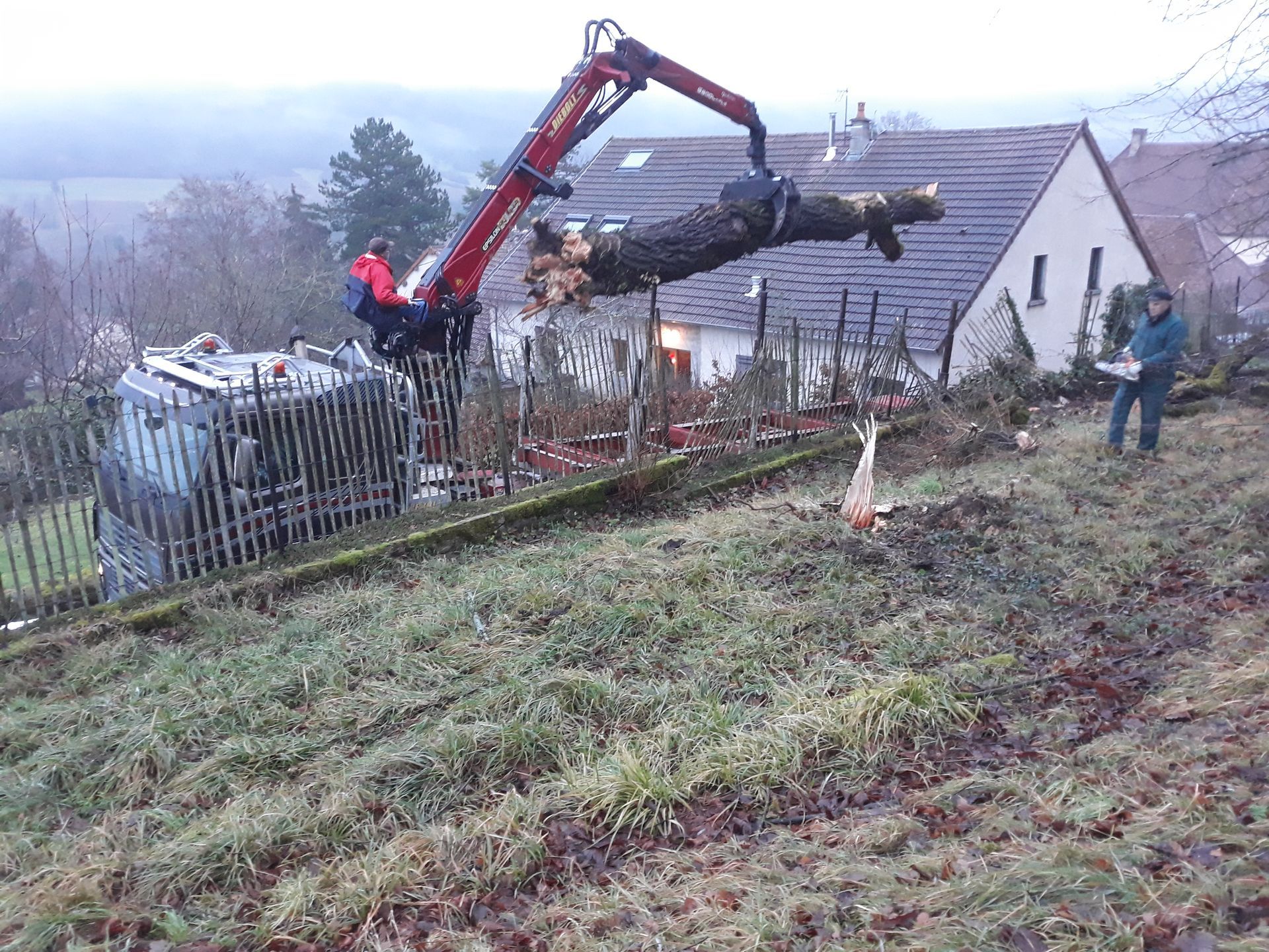 Un camion à bras qui soulève un tronc d'arbre
