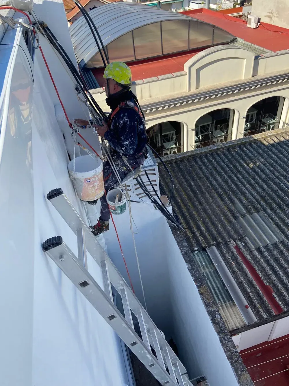 Vigas de canal de metal y madera apiladas al aire libre sobre una superficie de hormigón.
