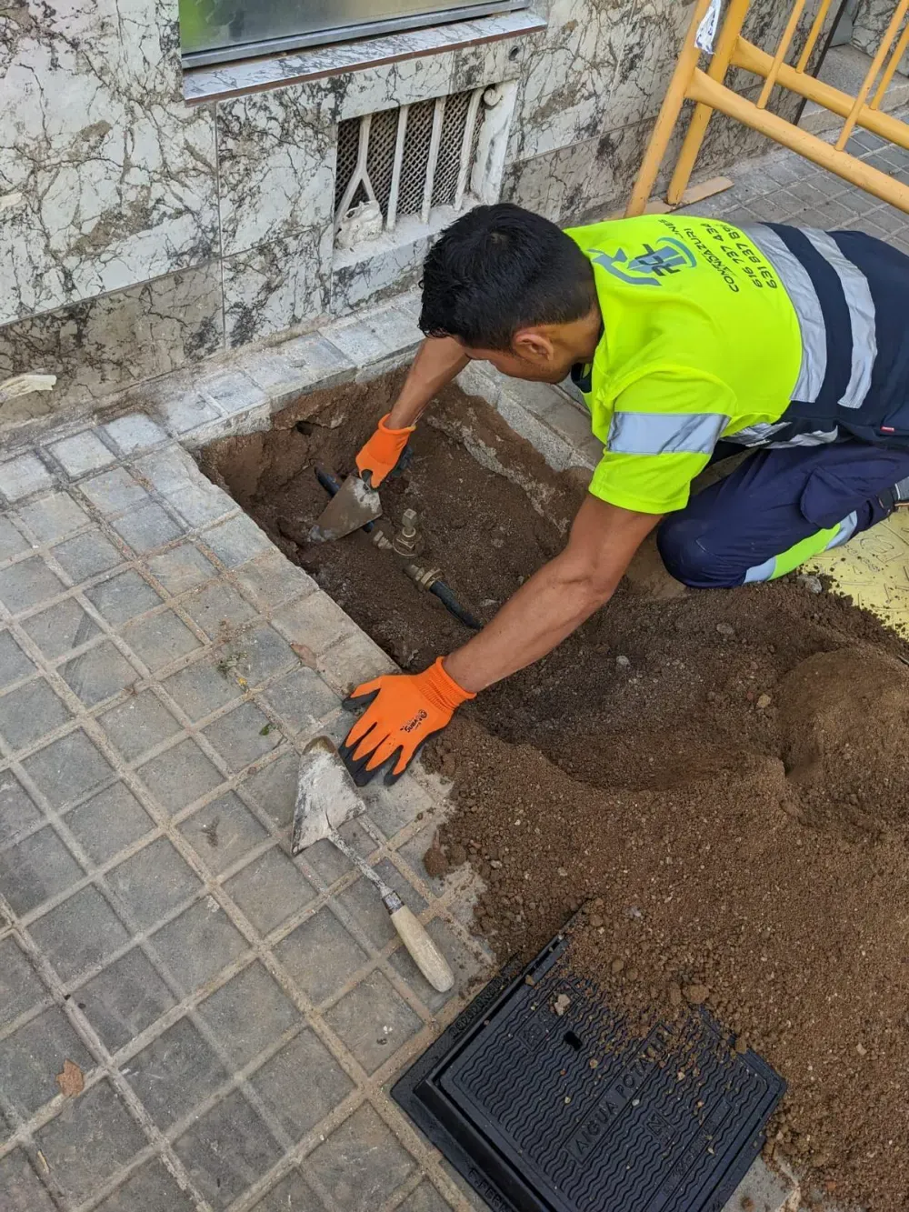 Limpiadores de ventanas limpiando paneles de vidrio en un edificio moderno, suspendidos por cuerdas.