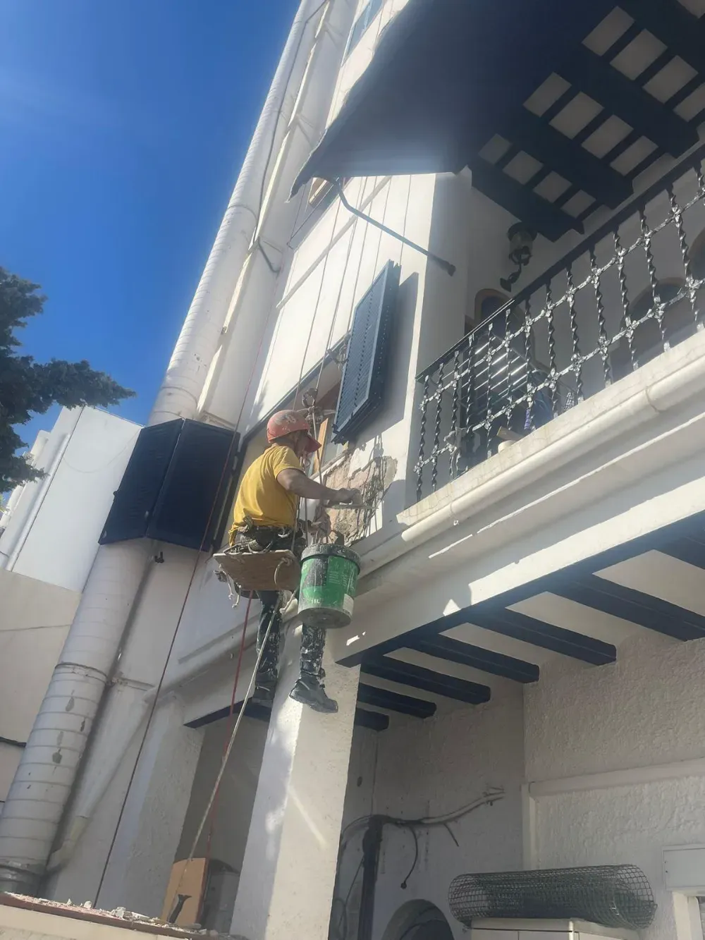 Habitación en construcción con paneles de yeso y ventanas selladas; un banco de trabajo.