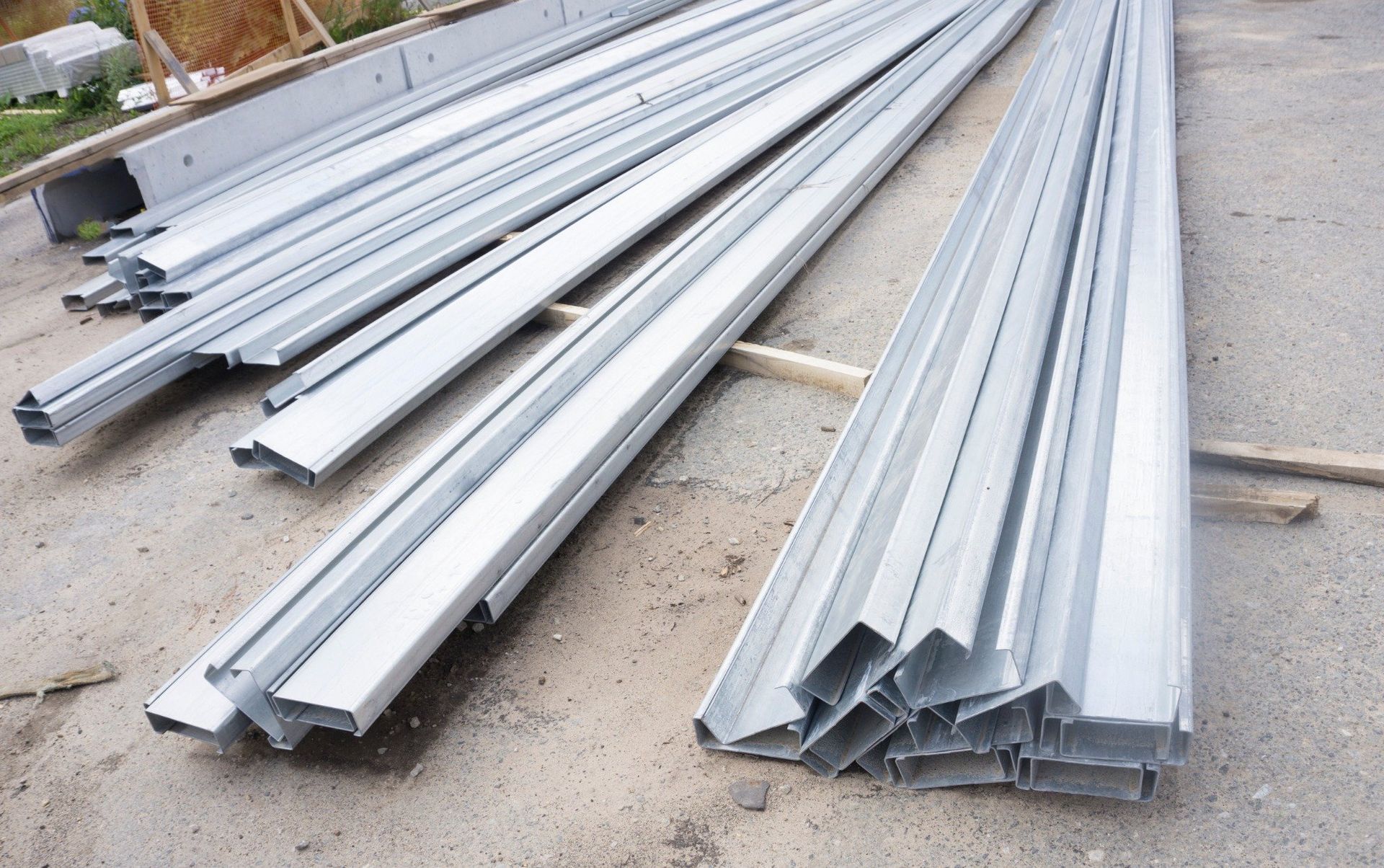 Material de estructura de metal apilado sobre una superficie de hormigón, listo para la construcción.