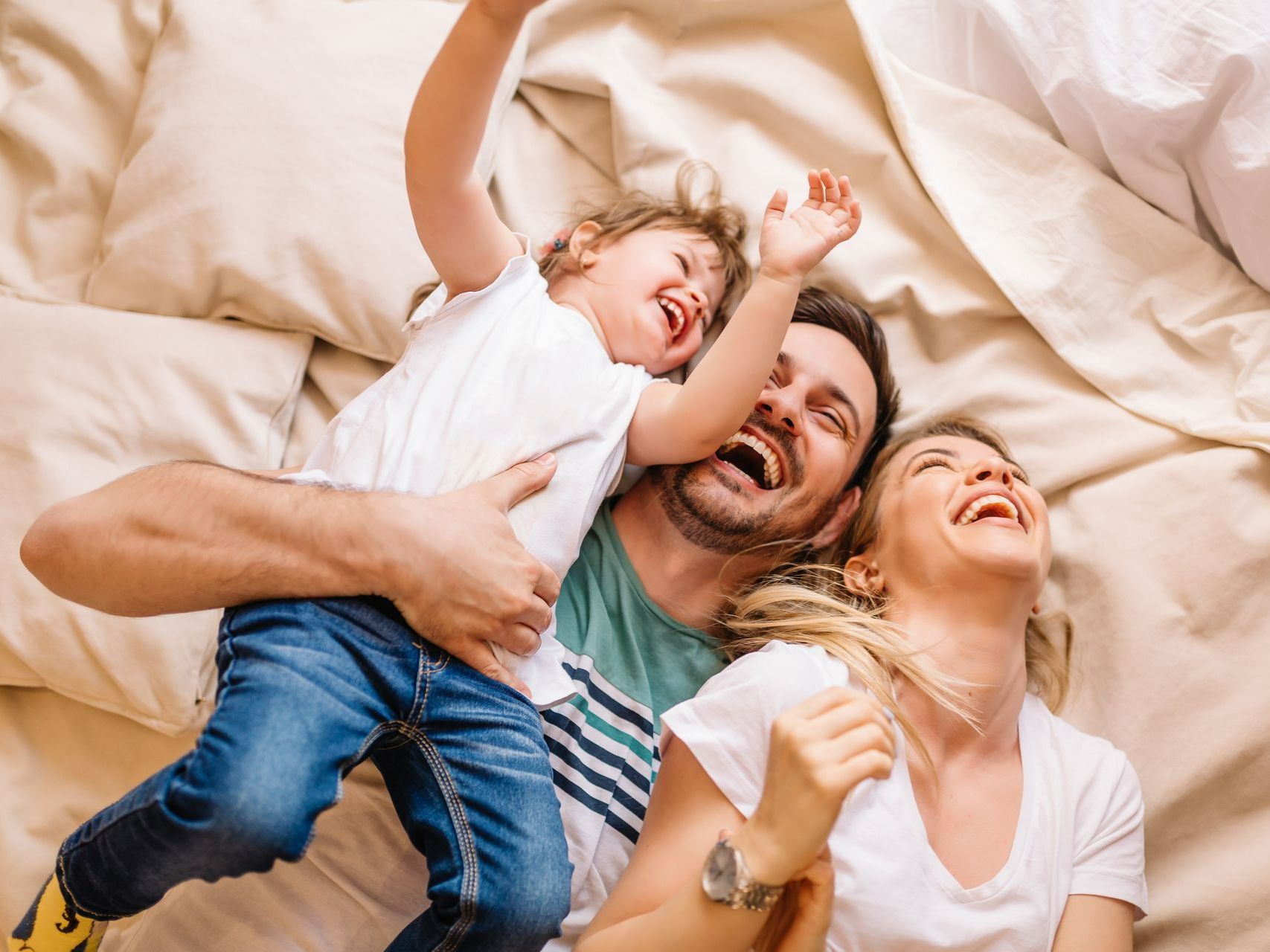 Famille jouant sur un lit