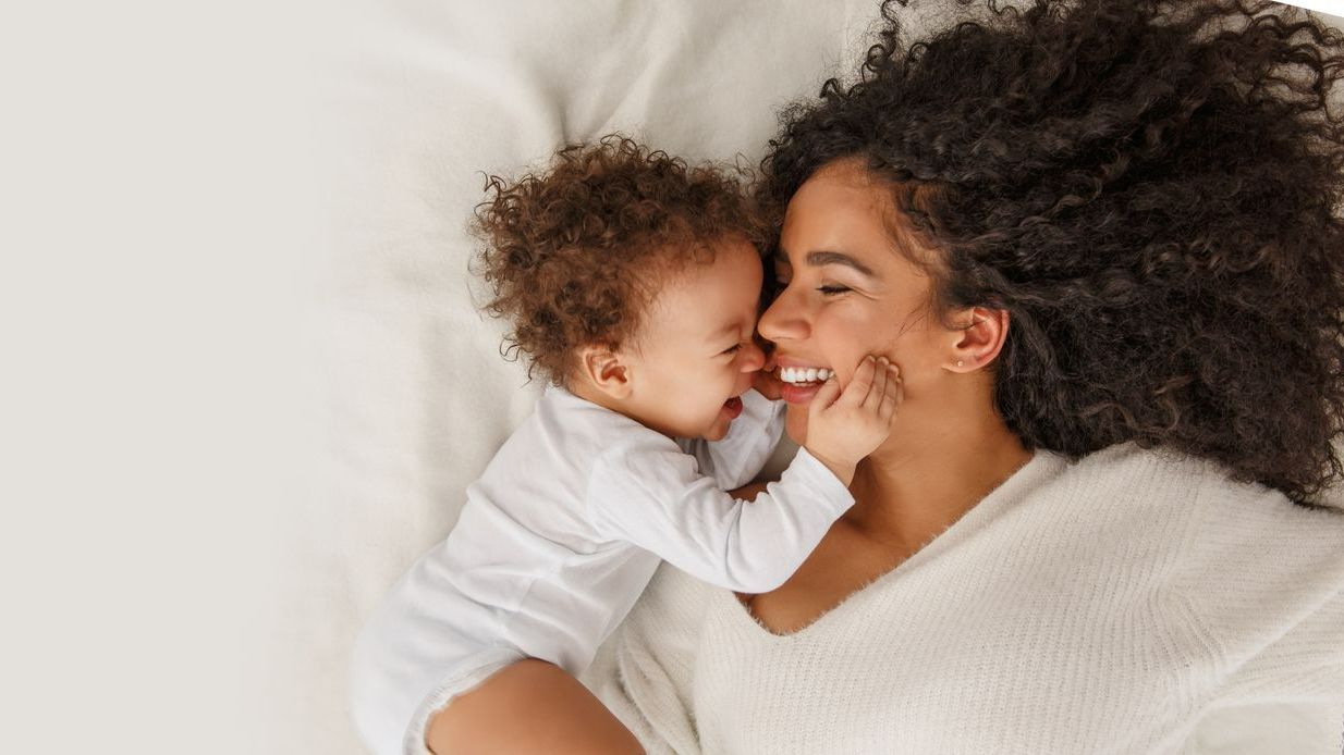 Jeune femme et son bébé sur un lit