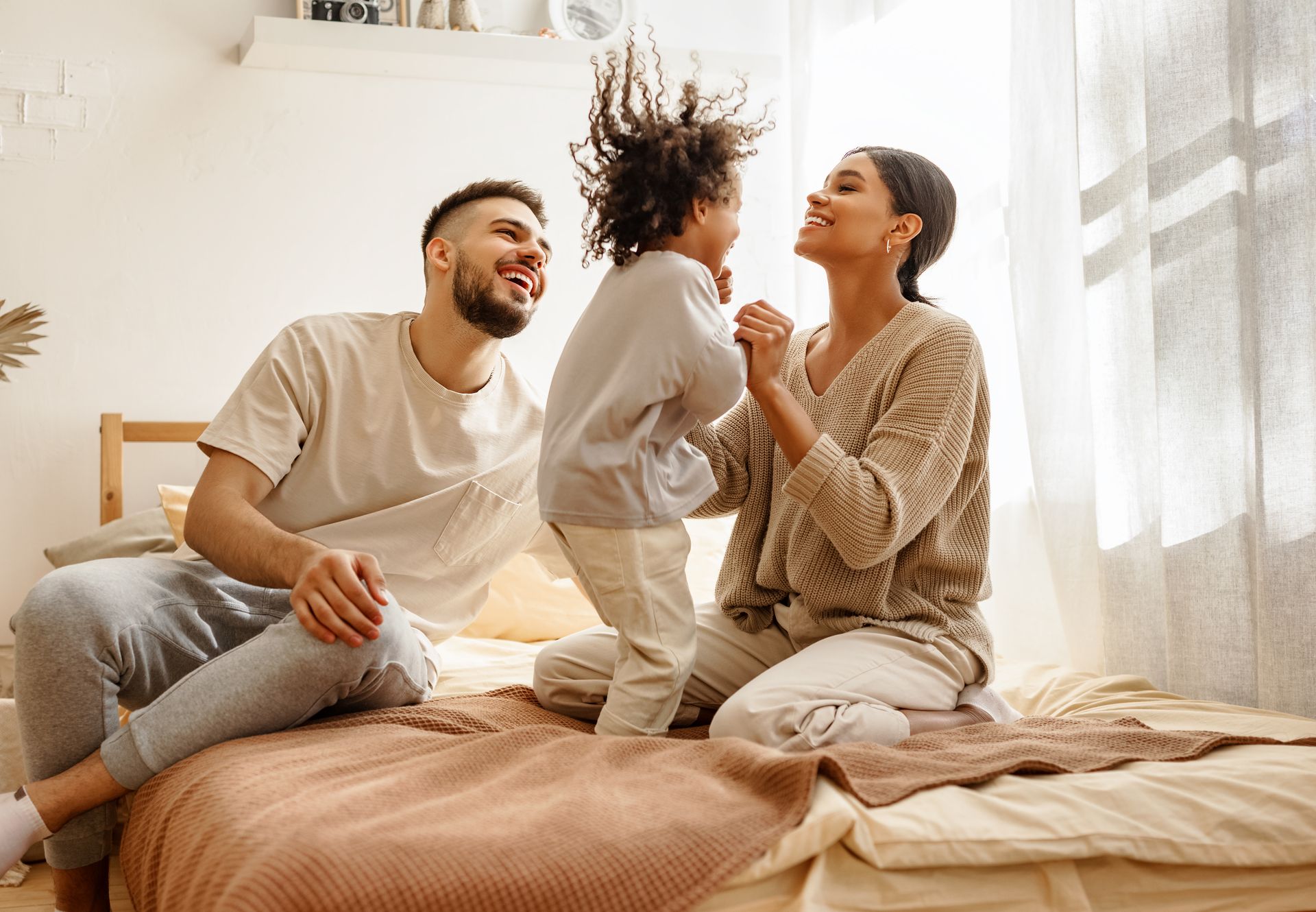 Couple avec leur enfant sur un lit