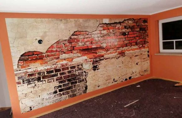 Ein Zimmer mit einem Bild einer Ziegelwand an der Wand