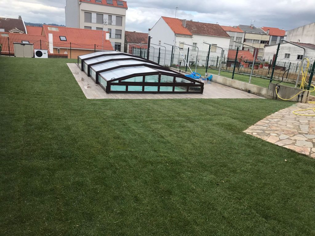 Una gran piscina está rodeada de un exuberante césped verde.