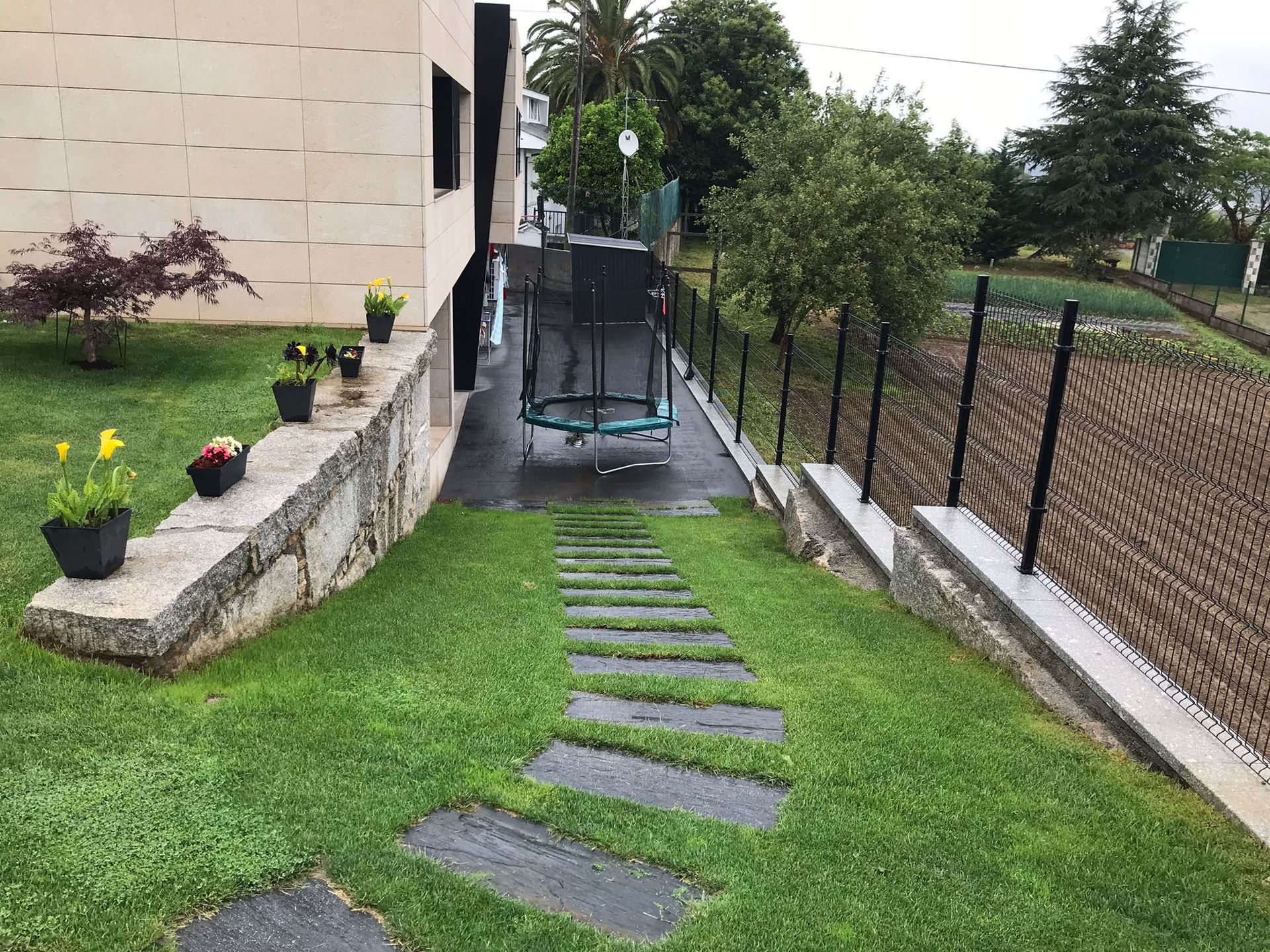 Hay un trampolín en el patio trasero de una casa.