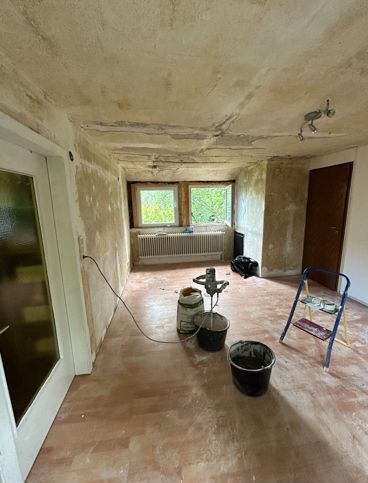 Ein Raum mit Holzboden und einer Leiter darin.