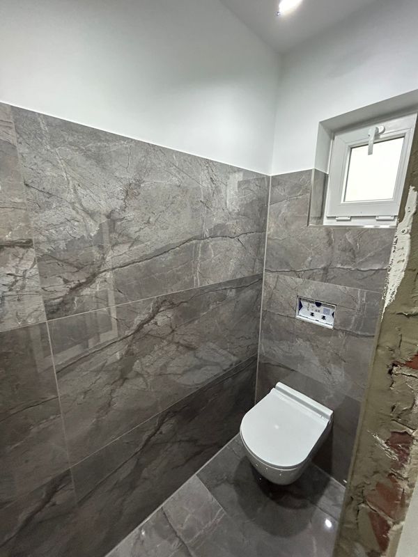 Ein Badezimmer mit Toilette und Fenster.