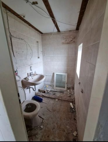 Ein Badezimmer mit Waschbecken, Toilette und Fenster.