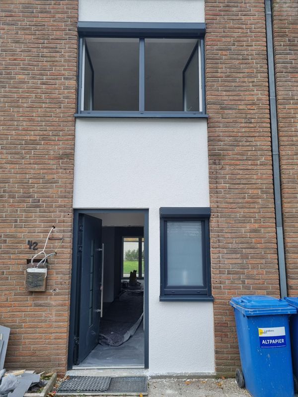 Ein Backsteingebäude mit einem blauen Mülleimer davor