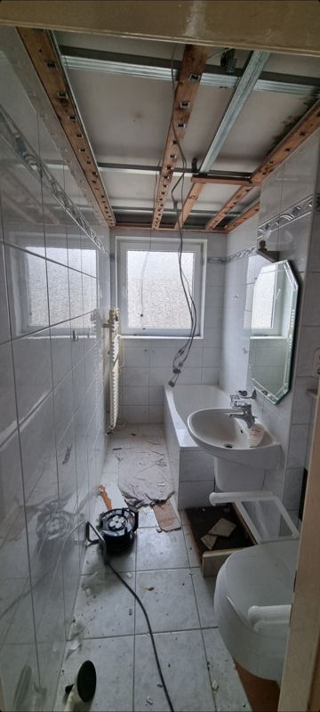 Ein im Bau befindliches Badezimmer mit Waschbecken, Toilette und Badewanne.