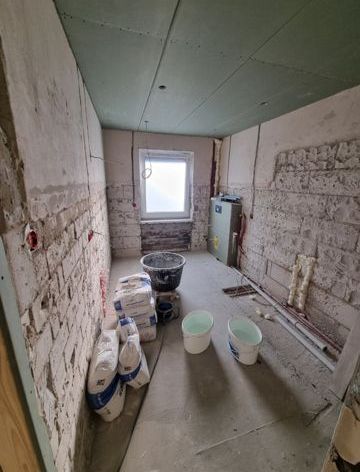 Ein Raum mit vielen Eimern auf dem Boden und einem Fenster.