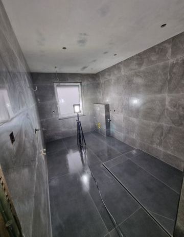 Ein großer Raum mit vielen Fliesen auf dem Boden und an den Wänden.