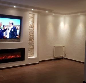 Ein Wohnzimmer mit Kamin und Flachbildfernseher.