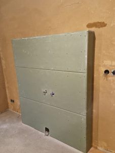 In einem Raum wird eine Wand mit einem Loch gebaut.