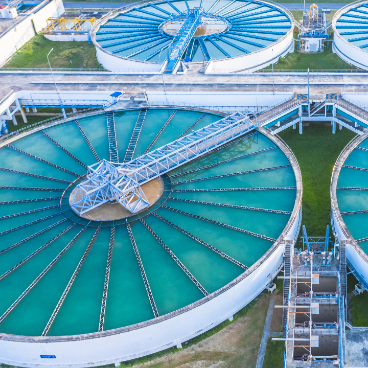 Vista aérea de una planta de tratamiento de agua con varios tanques circulares grandes 