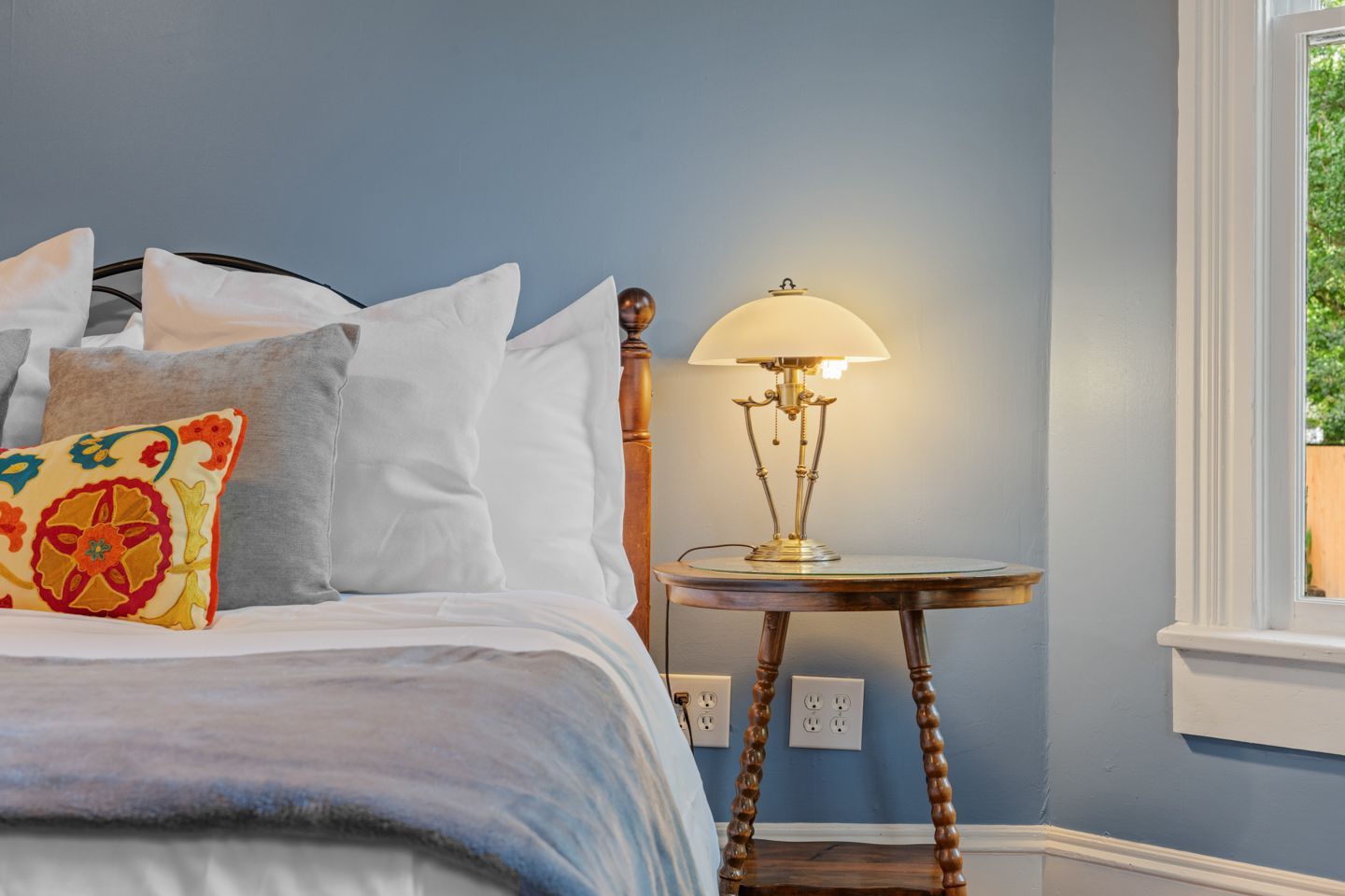Bedroom with bed, nightstand, lamp, and blue walls.