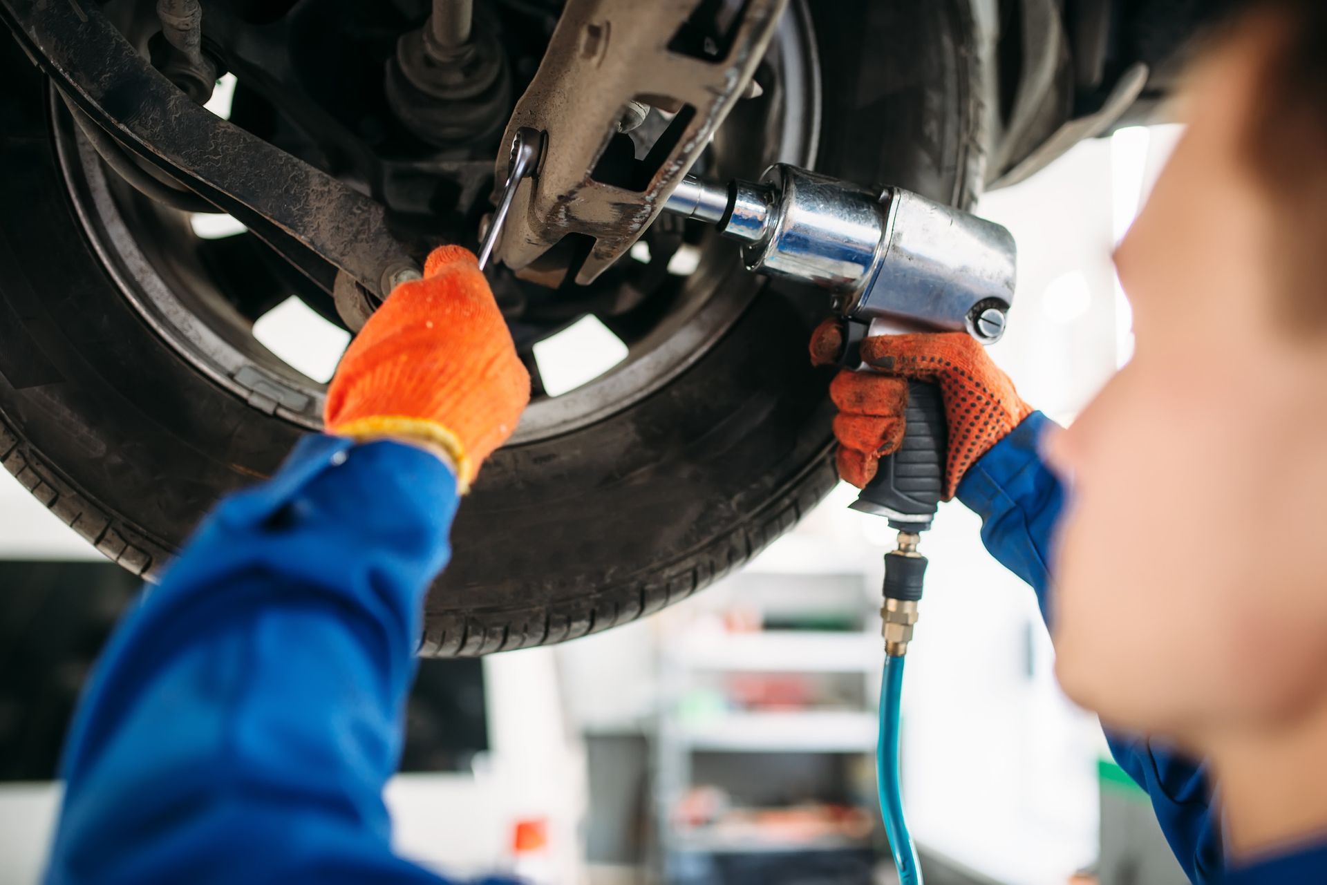 Un hombre está trabajando en una rueda de automóvil con una llave inglesa.