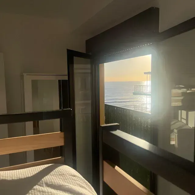 Una habitación con una cama y una ventana con vistas al mar.